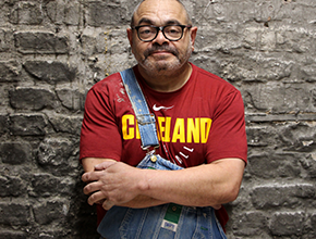 Man wearing red with arms folded